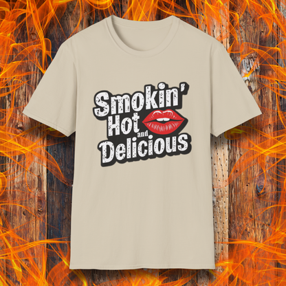 Sand t-shirt featuring bold white text that reads 'Smokin' Hot and Delicious,' with a red lips graphic replacing the 'o' in 'Hot' for a fun, flirty BBQ-inspired design