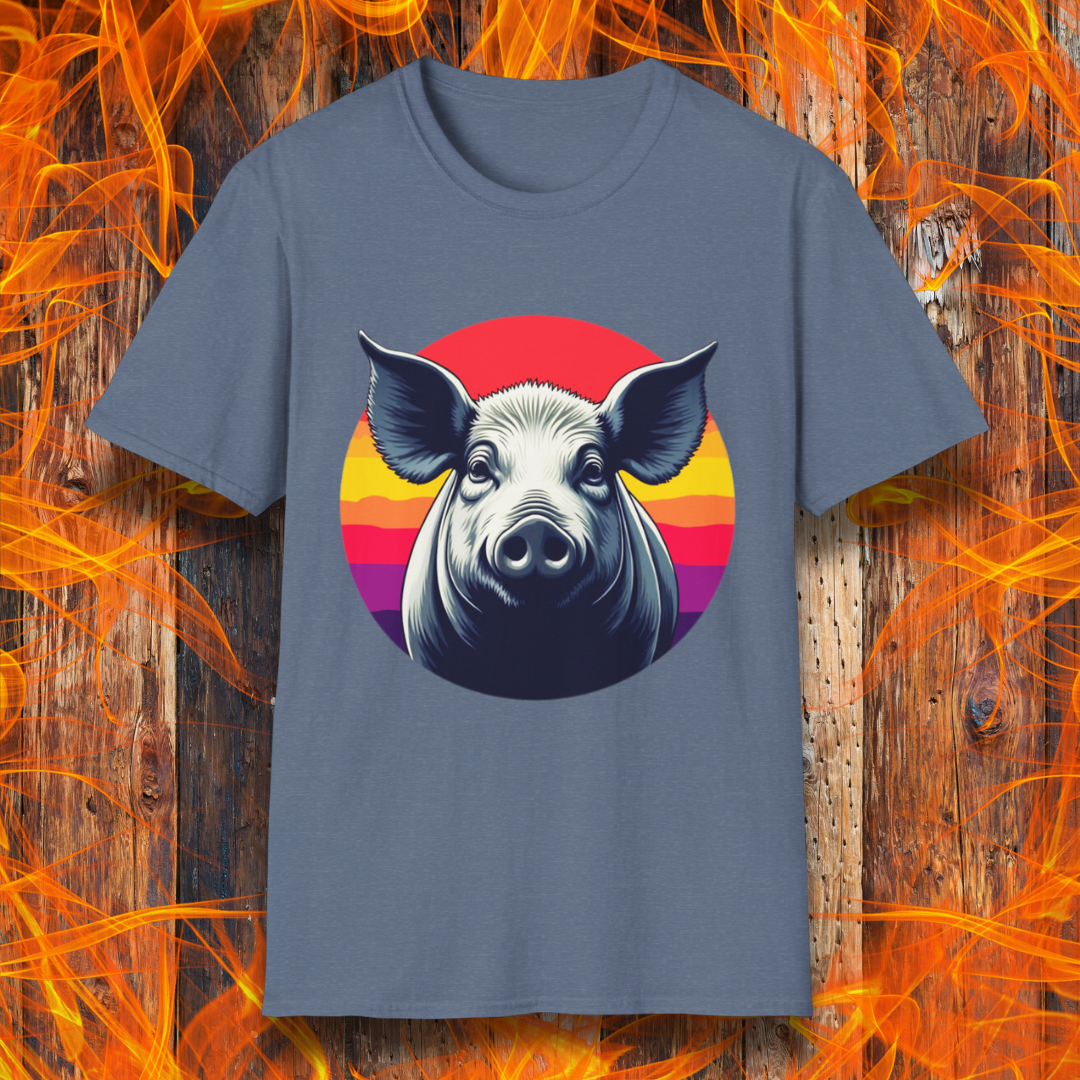 Heather Indigo T-shirt featuring a striking illustration of a pig's face in a bold, high-contrast style, set against a circular sunset background with vibrant red, orange, and purple hues. The design gives a rustic yet modern feel, making it an excellent choice for BBQ lovers.