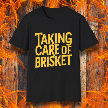 Black T-shirt with bold yellow text reading 'Taking Care of Brisket,' a fun BBQ-themed design inspired by classic rock and grilling culture.