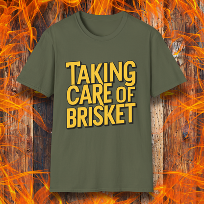 Military Green  T-shirt with bold yellow text reading 'Taking Care of Brisket,' a fun BBQ-themed design inspired by classic rock and grilling culture.