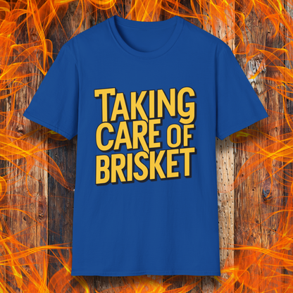 Royal Blue T-shirt with bold yellow text reading 'Taking Care of Brisket,' a fun BBQ-themed design inspired by classic rock and grilling culture.
