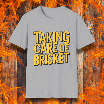 Sport Grey T-shirt with bold yellow text reading 'Taking Care of Brisket,' a fun BBQ-themed design inspired by classic rock and grilling culture.