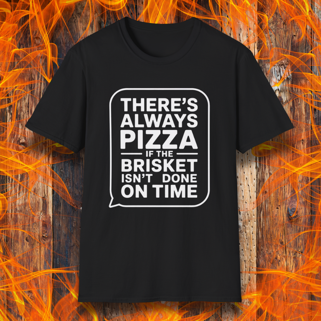 Black T-shirt featuring bold white text in a speech bubble that reads "There’s Always Pizza If the Brisket Isn’t Done on Time," displayed over a wooden background with flames — a humorous shirt for BBQ fans who know the struggle of low-and-slow cooking.